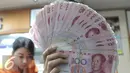 Seorang teller memperlihatkan mata uang Yuan di Jakarta, Senin (30/11). Dana Moneter Internasional (IMF), Senin (30/11), resmi memasukan yuan, atau renminbi, ke dalam special drawing rights (SDR) sebagai mata uang elite dunia. (Liputan6.com/Angga Yuniar)