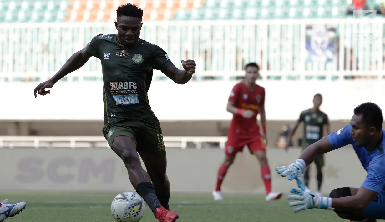 Gelandang Tira Persikabo, Osas Saha, berusaha melewati kiper Kalteng Putra, Dimas Galih, pada laga Shopee Liga 1 di Stadion Pakansari, Bogor, Jumat (26/7). Tira Persikabo menang 5-2 atas Kalteng. (Bola.com/Yoppy Renato)