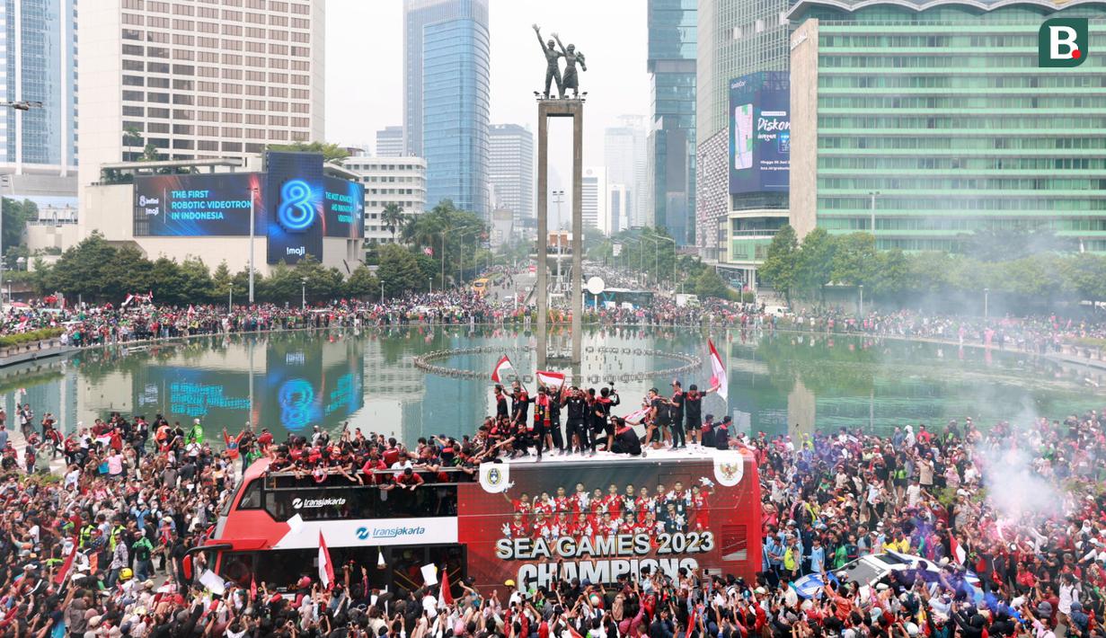 <p>Sejumlah suporter melakukan perayaan bersama pemain Timnas Indonesia U-22 saat mengikuti parade perayaan kesuksesan Timnas Indonesia U-22 di SEA Games 2023 Kamboja di Bundaran Hotel Indonesia, Jakarta, Jumat (19/05/2023). (Bola.com/M Iqbal Ichsan)</p>
