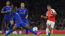 Penyerang Arsenal, Alexis Sanchez berebut bola dengan striker Olympiacos, Seba pada laga Liga Champions di Stadion Emirates, Inggris, Rabu (30/9/2015). (AFP Photo/Glyn Kirk)