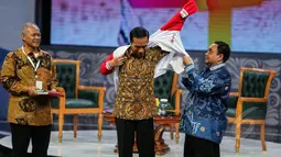 Presiden Joko Widodo mendapatkan jaket spesial saat menghadiri Silatuhrahmi Pers Nasional di gedung Auditorium  TVRI, Jakarta, Senin (27/4/2015). Tampak Jokowi mengenakan jaket berwarna merah putih pemberian Ketua PWI Margiono (Liputan6.com/Faizal Fanani)