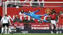 <p>Penjaga gawang Manchester United, David de Gea (tengah), berhasil menghalau tendangan dari pemain Fulham dalam pertandingan yang berlangsung di Old Trafford, Minggu (19/3/2023). (AFP/Paul Ellis)</p>