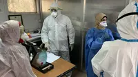 Anggota tim pakar medis China, Yang Honghui (kanan) memasuki Laboratorium Kesehatan Masyarakat Pusat di Baghdad, Irak, Kamis (26/3/2020). Sejak 7 Maret lalu, tujuh pakar medis China bekerja sama dengan tenaga ahli lokal di Irak untuk memerangi epidemi virus corona COVID-19. (Xinhua)