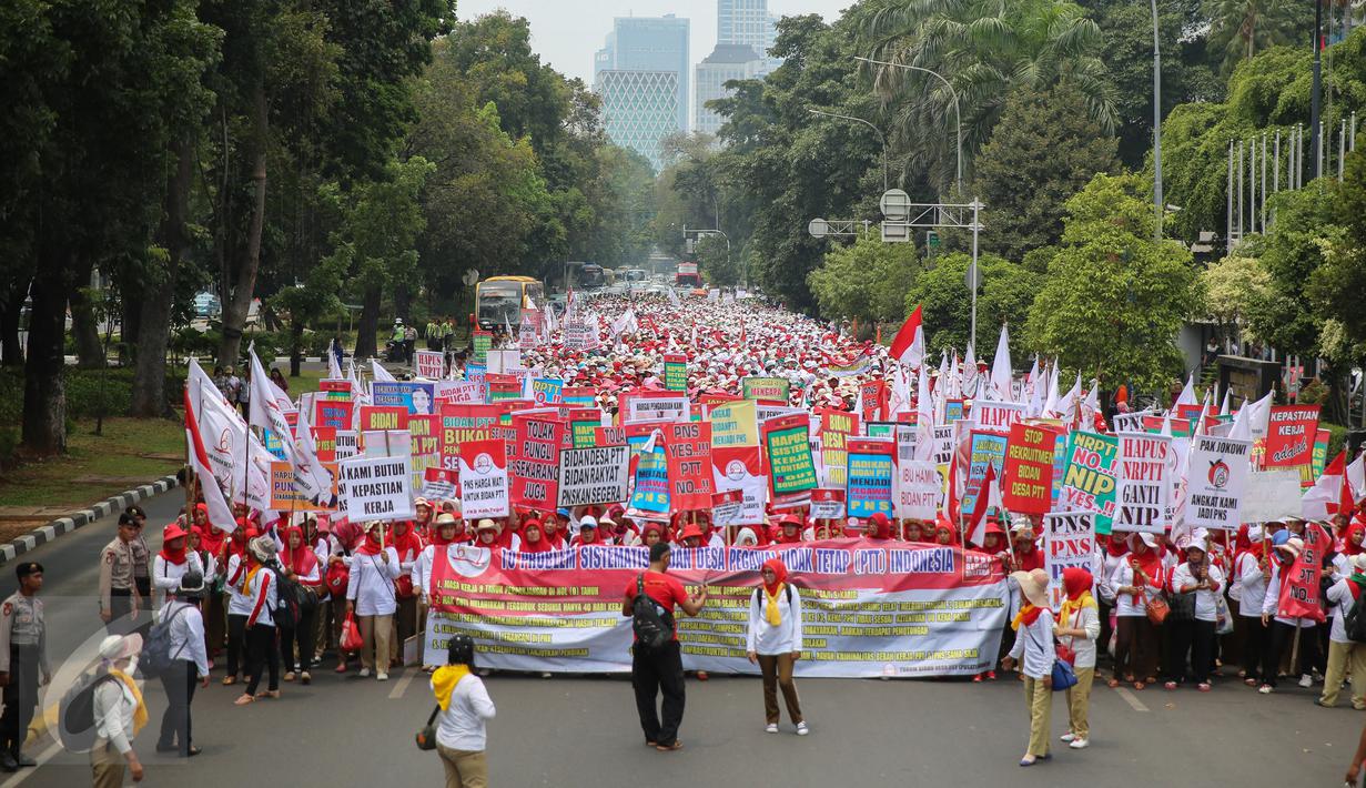 Ribuan bidan dari berbagai daerah melakukan long march dari depan Patung Kuda menuju Istana Merdeka, Jakarta, Senin (28/9/2015). Mereka menuntut pengangkatan status kepegawaian menjadi pegawai negeri sipil (PNS). (Lipuutan6.com/Faizal Fanani)