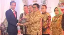 Presiden Joko Widodo menerima buku dari Ketua DPD Oesman Sapta Odang saat acara Sarasehan Nasional DPD RI di Senayan, Jakarta, Jumat (17/11). (Liputan6.com/Angga Yuniar)