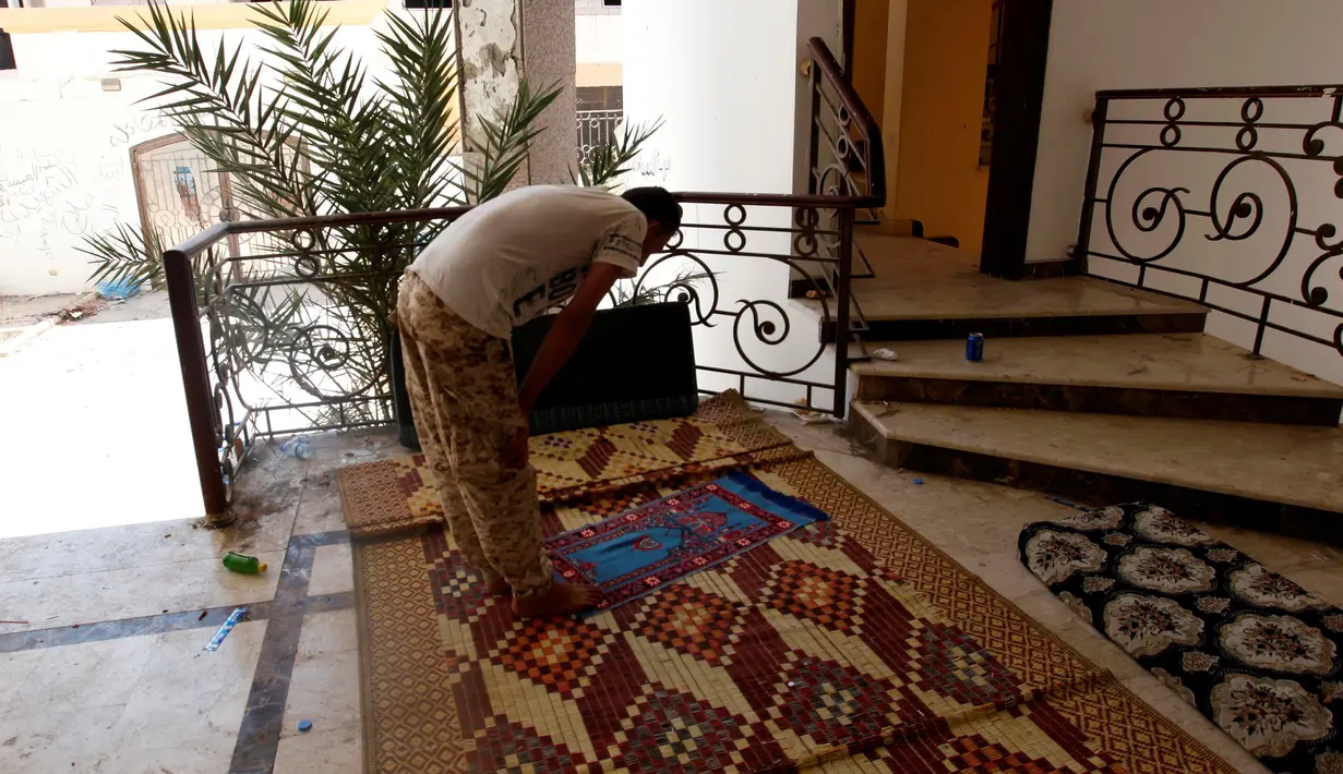 Seorang anggota pasukan Libya menunaikan salat saat pertempuran melawan militan ISIS di Sirte, Libya, (15/8). foto militer Libya sedang menunaikan salat yang beredar luas menuai pujian netizen. (REUTERS/Ismail Zitouni)