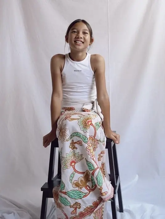 Punya kulit eksotis, Kiyomi pun nampak pas mengenakan tank top putih dipadukan kain batik sebagai bawahan. (@jenniferbachdim)