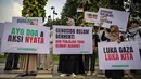 Para aktivis menggelar unjuk rasa menentang pencegatan kapal-kapal yang berpartisipasi dalam armada Global Sumud Flotilla (GSF), sebuah misi bantuan kemanusiaan ke Gaza melalui jalur laut, di Surabaya, Jawa Timur pada Kamis 21 Mei 2026. (JUNI KRISWANTO/AFP)
