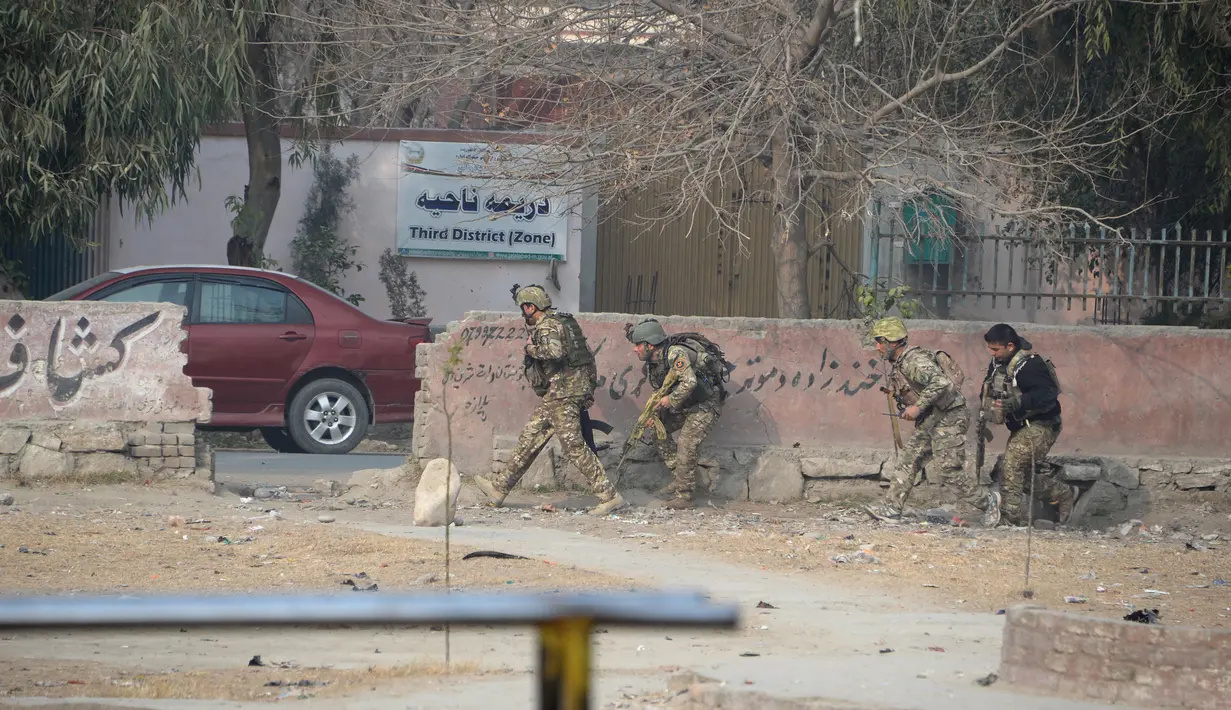 Tentara Afghanistan mengambil posisi di dekat sebuah kantor amal Inggris Save the Children saat terjadi serangan yang sedang berlangsung di Jalalabad, Afghanistan (24/1). (AFP Photo/Noorullah Shirzada)