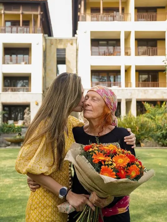 Sambil mencium sang ibu, Ia juga memegang beberapa buket bunga yang sepertinya pemberian dari keluarga dan orang-orang tersayang. (Instagram/lunamaya).