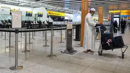 Diketahui, setidaknya ada delapan negara di kawasan Timur Tengah menyatakan menutup wilayah udaranya. Tampak dalam foto, seorang pria berdiri di depan konter check-in yang tutup milik maskapai penerbangan Etihad di Bandara Heathrow, London pada Minggu 1 Maret 2026. (JUSTIN TALLIS/AFP)