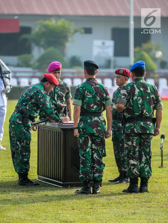 Panglima TNI Marsekal Hadi Tjahjanto menandatangani dokumen saat meresmikan Komando Operasi Khusus (Koopssus) TNI di Lapangan Markas Koopssus TNI, Mabes TNI, Jakarta, Selasa (30/7/2019). Koopssus TNI bertugas memberikan dukungan dalam operasi khusus. (Liputan6.com/Faizal Fanani)