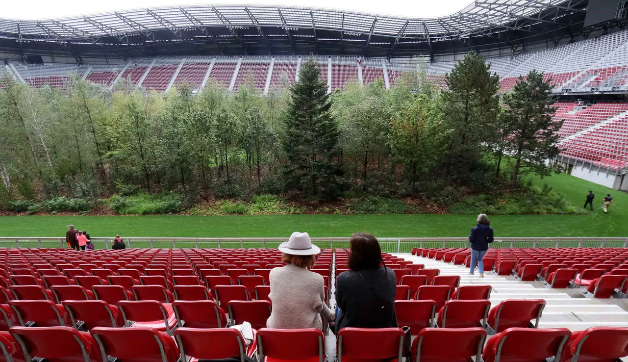 Pengunjung melihat instalasi ekosistem hutan di Stadion Woerthersee, Austria, Minggu (8/9/2019). Tempat itu kini lebih mirip seperti hutan yang telah ditumbuhi pepohonan di area lapangan dibanding tempat untuk bertanding sepak bola. (AP/Ronald Zak)
