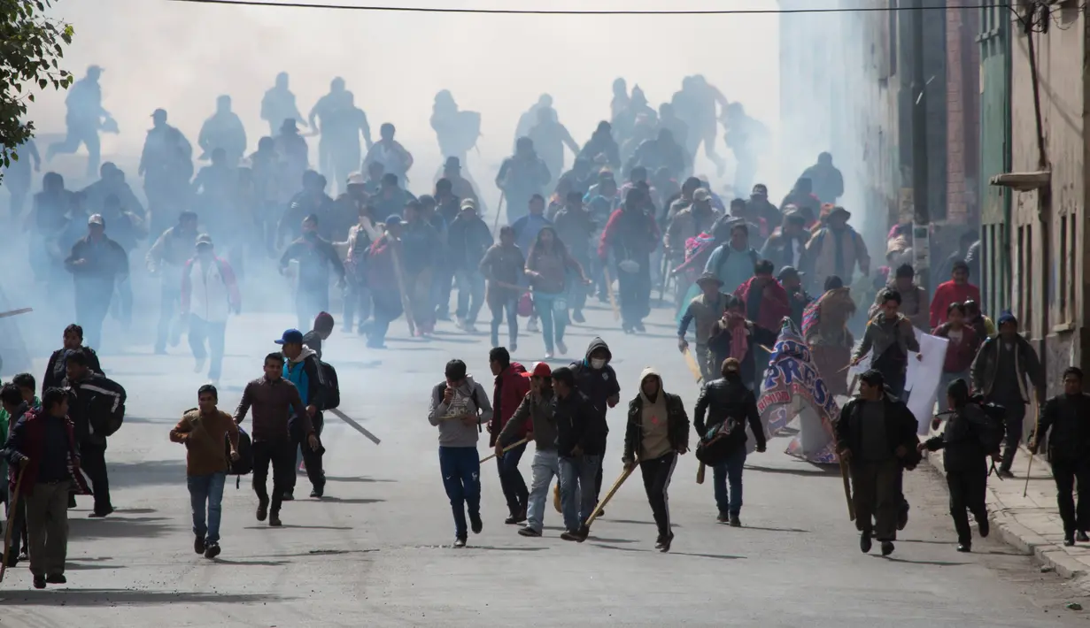 Ratusan petani daun koka membubarkan diri saat polisi melepaskan gas air mata di La Paz, Bolivia, Selasa (21/2). Mereka protes kebijakan baru Presiden Evo Morales terkait petani daun koka. (AP Photo / Juan Karita)
