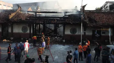 Petugas pemadam kebakaran dan warga berkumpul di lokasi kebakaran yang melanda kompleks Kelenteng Tay Kak Sie di Gang Lombok, Semarang, Kamis (21/3). Dilaporkan satu orang tewas dalam insiden kebakaran ini. (Liputan6.com/Gholib)