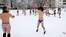 Para peserta melakukan pemanasan sebelum mengikuti Underpants Run di tepi sungai Danube, Serbia pada 26 Januari 2019. Peserta berlari hanya dengan mengenakan pakaian dalam di tengah suhu yang mendekati 0 derajat Celcius. (AP/Darko Vojinovic)