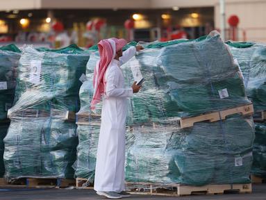 Seorang sukarelawan memeriksa paket bantuan yang disediakan oleh Arab Saudi sebelum dimuat ke dalam pesawat Kargo Saudi di bandara Internasional King Fahad di Riyadh pada 14 Oktober 2024. (Fayez Nureldine/AFP)