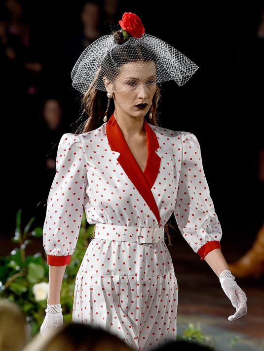 Bella Hadid berjalan di catwalk untuk show Rodarte pada New York Fashion Week: The Shows di New York City, Selasa (11/2/2020). Bella Hadid seolah-olah kembali ke era tahun 50an dalam balutan gaun polkadot merah dan putih dengan kerudung yang menutupi wajahnya. (Dimitrios Kambouris/Getty Images/AFP)