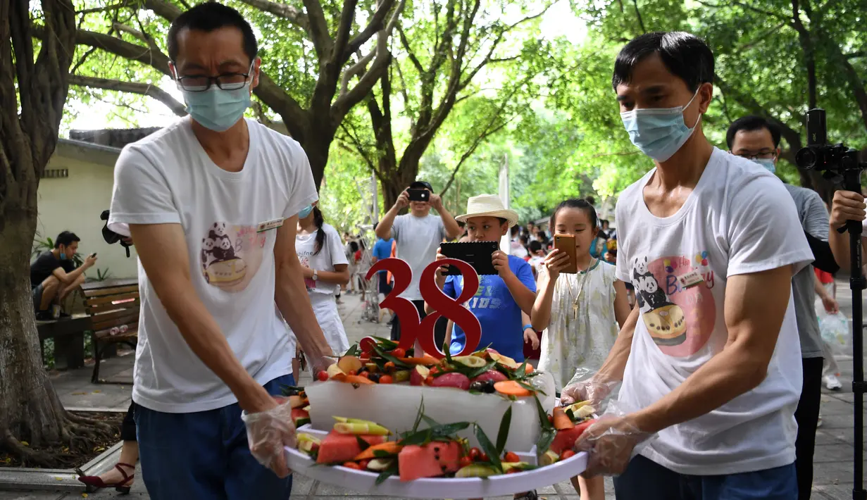 Staf membawa kue ulang tahun spesial untuk panda raksasa Xinxing di Kebun Binatang Chongqing di Kota Chongqing, China pada 16 Agustus 2020. "Nenek panda" yang menjadi bintang di kebun binatang itu pada Minggu (16/8) berulang tahun ke-38, atau setara usia 110-150 tahun pada manusia. (Xinhua/Tang Yi)