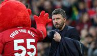 Pelatih sementara Manchester United asal Inggris, Michael Carrick (kanan), bertepuk tangan dengan maskot Fred the Red menjelang dimulainya pertandingan Liga Inggris antara Manchester United dan Brentford di Old Trafford, Manchester, barat laut Inggris, pada 28 April 2026. (Darren Staples/AFP)