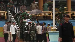 Personel TNI dan polisi membawa Menko Polhukam Wiranto menuju helikopter usai diserang orang tak dikenal di Pandeglang, Banten, Kamis (10/10/2019). Wiranto yang mengalami luka tusuk di bagian perut akibat penyerangan itu dibawa ke RSPAD Gatot Subroto, Jakarta dengan helikopter. (Photo by SAMMY/AFP)