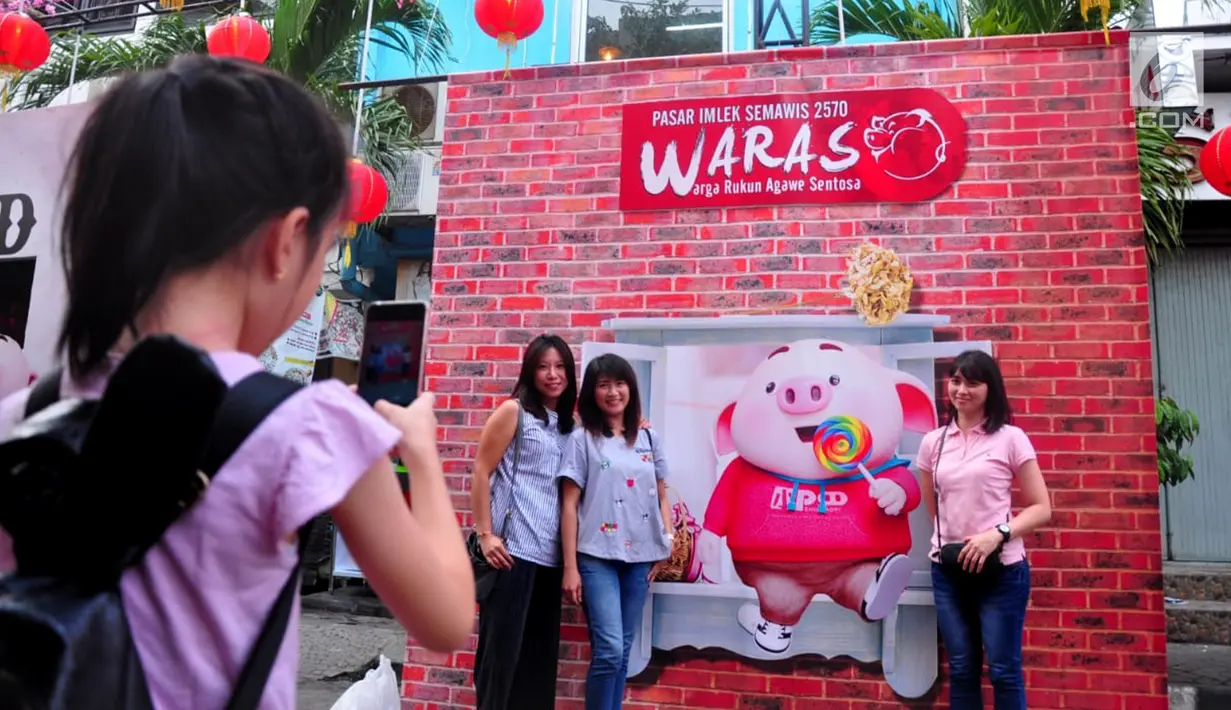 Warga foto bersama saat menikmati kemeriahan Pasar Imlek Semawis 2570 di kawasan Pecinan Semarang, Jawa Tengah, Sabtu (2/1). Pada tahun Babi Tanah ini Pasar Semawis mengusung tema 'Warga Rukun Agawe Santoso'. (Liputan6.com/Gholib)