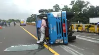 Kendaraan yang tengah mengangkut penumpang pasien positif Covid-19 terguling di Tol Jagorawi,Rabu (13/1/2021). (Liputan6.com/Achmad Sudarno)