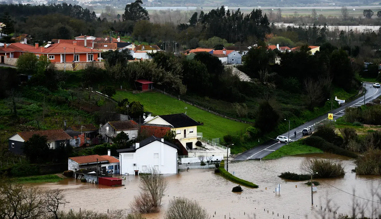 Pemukiman dan jalan utama tertutupi oleh luapan banjir yang terjadi di Coimbra, Portugal (14/2/2016). Badai besar yang melanda seluruh negara bagian Portugal menyebabkan gelombang tinggi dan banjir. (AFP Photo /Francisco Leong)