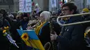 Puluhan musisi ambil bagian dalam pertunjukan flashmob "The Great Gate of Kyiv from pictures at an Exhibition" yang dipimpin seorang komposer Rusia-Inggris terkenal untuk menunjukkan dukungan terhadap Ukraina setelah invasi Rusia, di Trafalgar Square, London, Minggu (6/3/2022). (JUSTIN TALLIS/AFP)