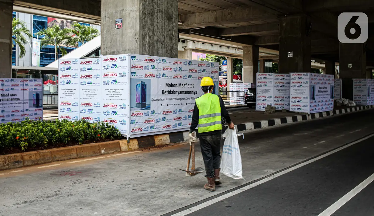Seorang pekerja melintas di bawah Stasiun MRT Haji Nawi, Jakarta, Minggu (4/10/2020). PT Mass Rapid Transit atau MRT Jakarta menyiapkan sejumlah pilar jalur MRT sebagai media iklan untuk mengembangkan bisnis di luar pendapatan tiket atau non-farebox. (Liputan6.com/Faizal Fanani)