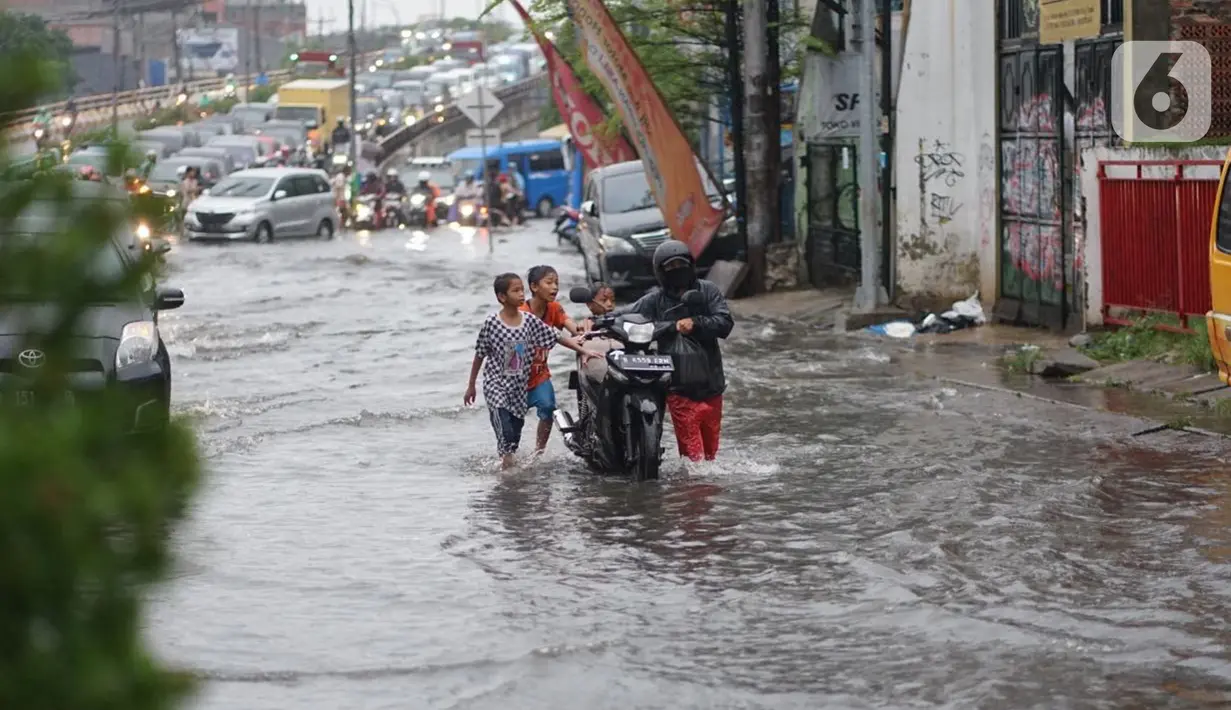 Pengendara mendorong motornya menerobos banjir yang menggenangi Jalan Arif Rahman Hakim di Depok, Jawa Barat, Senin (18/5/2020). Sistem drainase buruk menjadi penyebab utama kawasan tersebut selalu tergenang banjir setiap hujan deras. (Liputan6.com/Immanuel Antonius)
