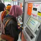 Calon penumpang membeli tiket di mesin penjual tiket kereta api otomatis di Stasiun Senen, Jakarta, Selasa (20/12). Jelang libur Natal dan tahun baru tiket Kereta Api sudah habis untuk keberangkatan Jateng dan Jatim. (Liputan6.com/Angga Yuniar)