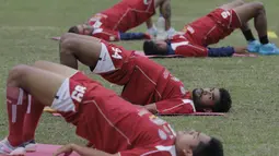 Pemain Arema Cronus, Ferry Aman Saragih merenggangkan otot saat latihan jelang leg kedua semi final Piala Presiden melawan Sriwijaya F.C di Stadion Gajayana, Malang, Rabu (7/10/2015). (Bola.com/Vitalis Yogi Trisna)