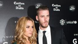 Kiper Manchester United, David de Gea (kanan) dan pacarnya Edurne Garcia berpose di atas karpet merah saat mereka tiba untuk menghadiri "Inggris untuk UNICEF Gala Dinner" di Old Trafford, Manchester, Inggris, (29/11). (AFP PHOTO/OLI SCARFF)