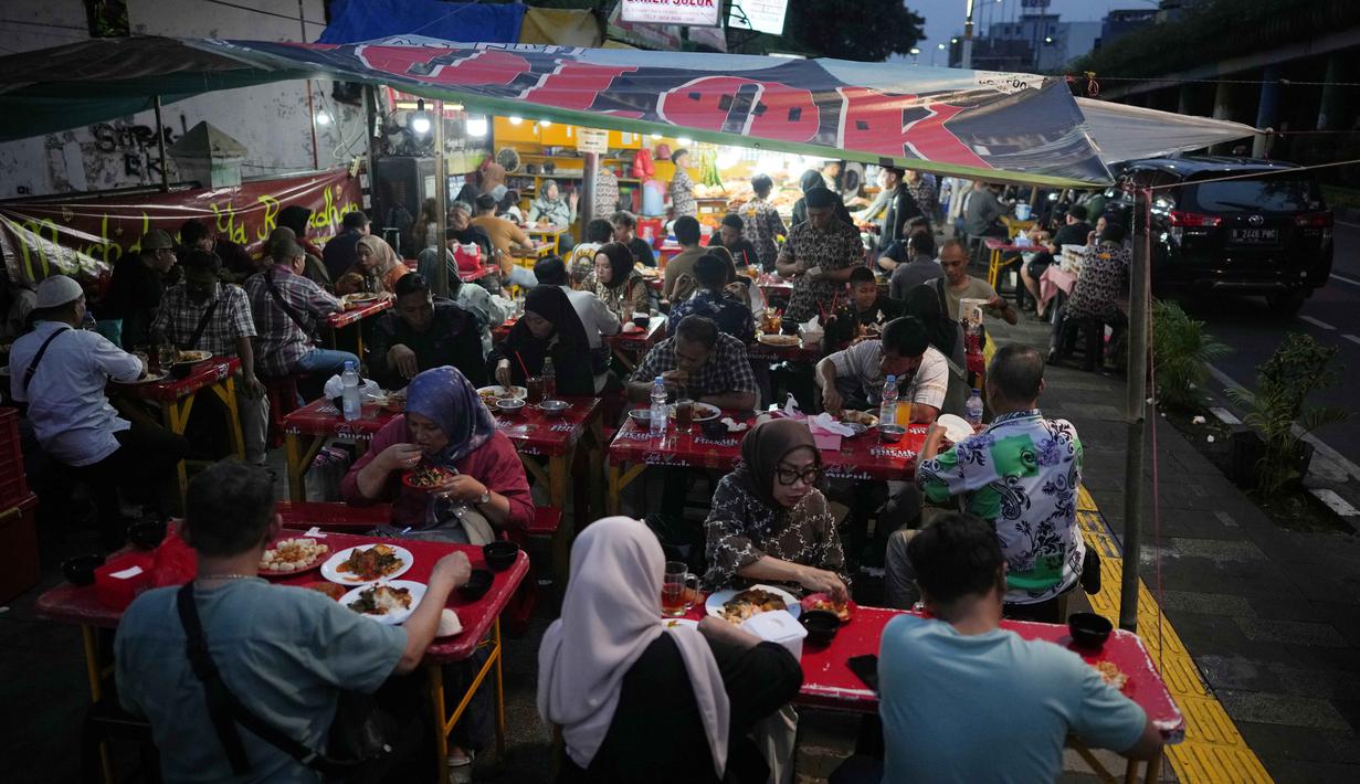 Aneka menu lauk untuk Nasi Kapau dihidangkan seperti gulai tambusu, ayam pop, rendang, jengkol balado, dendeng batokok dan masih banyak lagi. Tampak dalam foto, orang-orang berbuka puasa di sebuah warung makan pinggir jalan pada hari kedua bulan suci Ramadan 1447 Hijriah di Jakarta, Jumat 20 Februari 2026. (AP Photo/Dita Alangkara)