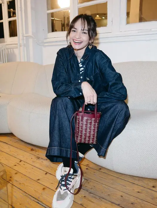 Sebelumnya ia tampil casual dengan setelan denim dari atasan kemeja lengan panjang serasi dengan celananya. Dipadukan sneakers, sambil membawa mini bag maroon.  [@enzystoria]