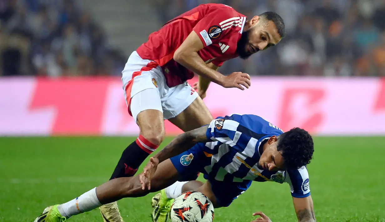 Bek Manchester United, Noussair Mazraoui (atas) berebut bola dengan pemain FC Porto, Wenderson Galeno berebut bola saat laga matchday 2 League Phase Liga Europa 2024/2025 di Estadio do Dragao, Porto, Kamis 3 Oktober 2024 atau Jumat (4/10/2024) dini hari WIB. (MIGUEL RIOPA/AFP)