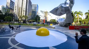 Instalasi seni bertajuk "Art Eggcident", karya seniman Belanda Henk Hofstra, patung telur goreng raksasa, menutupi halaman di luar sebuah gedung komersial di Sao Paulo, Brasil, Rabu, 20 September 2023. (AP Photo/Andre Penner)