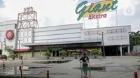 Pengunjung melintas di depan Supermarket Giant Ekstra di Kreo, Tangerang, Senin (2/8/2021). PT Hero Supermarket Tbk resmi menutup seluruh gerai Giant di Indonesia pada Minggu (1/8/2021), dan akan lebih fokus pada pengembangan gerai merek lainnya. (Liputam6.com/Faizal Fanani)