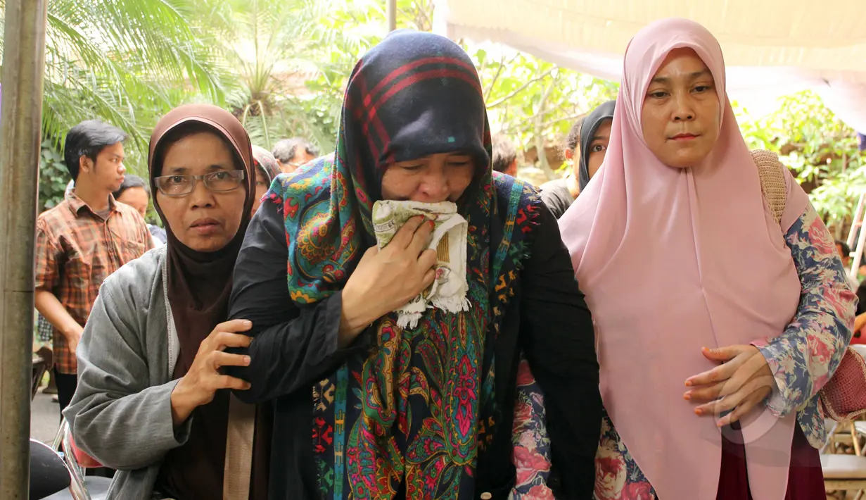 Uce Sriasih (tengah) istri Didi Widiatmoko alias Didi Petet terlihat menangis di rumah duka di kawasan Ciputat, Tangsel, Jumat (15/5/2015). Didi Petet meninggal di usia 58 tahun karena diduga menderita asam lambung. (Liputan6.com/Helmi Afandi)
