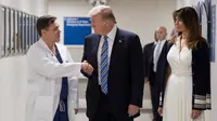 Presiden AS Donald Trump (tengah) berjabat tangan dengan dokter Igor Nichiporenko (kiri) saat mengunjungi rumah sakit Broward Health North Pompano Beach, Florida (16/2). (AFP Photo/Jim Watson)