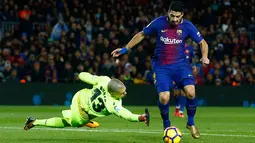 Pemain Barcelona, Luis Suarez berusaha menghindari kiper Deportivo La Coruna, Ruben Martinez pada pertandingan pekan ke-16 La Liga di Stadion Camp Nou, Senin (18/12). Barcelona unggul 4-0 tamunya La Coruna lewat dua gol Suarez. (AP/Manu Fernandez)