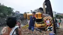 Seorang anak berpose dibelakang crane yang jatuh ke Sungai Ciliwung Kelurahan Bukit Duri, Jakarta Selatan  (1/10/15). Akibatnya seorang warga RT15/10 Kelurahan Bukit Duri, Jakarta Selatan harus mendapatkan perawatan medis. (Liputan6.com/Gempur M Surya)