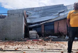 Seorang pria berbicara di telepon selulernya di dekat sebuah bangunan yang rusak akibat gempa di Palu, Sulawesi Tengah, Selasa 16 Juni 2026. (AP Photo/Josua Marunduh)