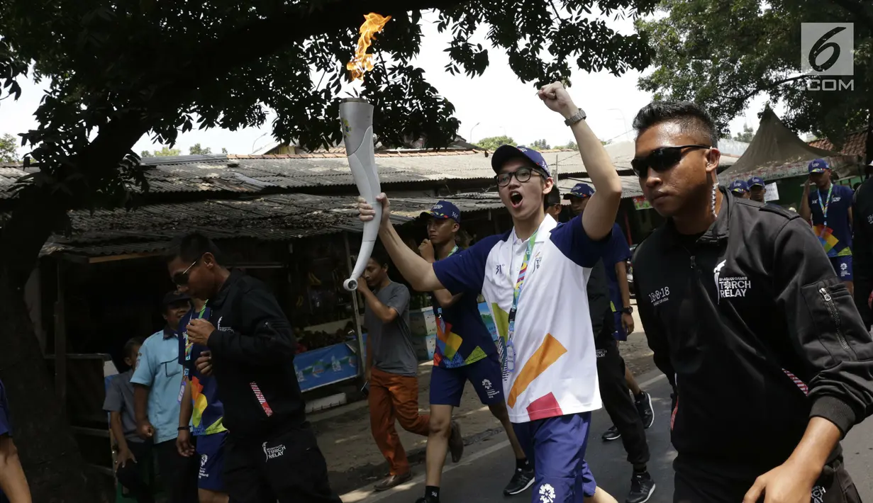 Aktor Brandon Salim berlari membawa obor Asian Games saat Torch Relay Asian Games 2018 di Cipayung, Jakarta Timur, Rabu (15/8). Pada 18 Agustus 2018, api abadi akan singgah di pemberhentian terakhirnya, Gelora Bung Karno. (Kapanlagi.com/Agus Apriyanto)