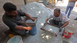 Para pekerja menyaring pecahan kaca di sebuah pabrik kaca di Tripoli, Lebanon, 12 September 2020. Kaca-kaca dari bangunan yang rusak akibat ledakan Beirut didaur ulang oleh warga setempat untuk dijadikan barang pecah belah. (Xinhua/Bilal Jawich)