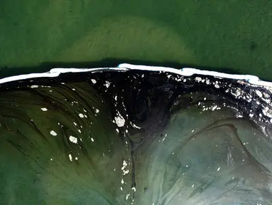 Foto udara menunjukkan penghalang dibuat untuk mencoba menghentikan tumpahan minyak ke Wetlands Talbert Marsh di Huntington Beach, California, Amerika Serikat, 4 Oktober 2021. Tumpahan sekitar 480 liter minyak mencemari laut dan pantai di California. (AP Photo/Ringo H.W. Chiu)