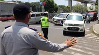 Polisi memberhentikan kendaraan saat pengendalian mobilitas ganjil genap untuk pengunjung TMII di Jalan Pintu 1 TMII, Jakarta, Sabtu (18/9/2021). Pembatasan mobilitas pada TMII dan Taman Impian Jaya Ancol dilakukan pada hari Jumat-Minggu mulai pukul 12.00-18.00 WIB. (Liputan6.com/Herman Zakharia)