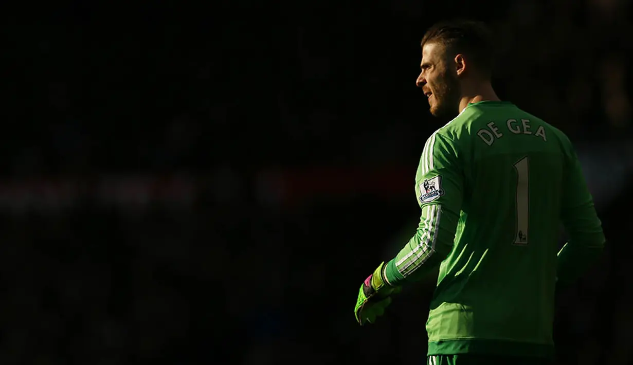 1. Kiper Manchester United, David De Gea, tampak silau terkena sorot mahahari saat laga Liga Premier Inggris melawan Arsenal di Stadion Old Trafford, Minggu (28/2/2016). MU berhasil menaklukan Arsenal 3-2. (Reuters/Jason Cairnduff)