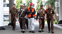 Buronan koruptor Atto Sakmiwata Sampetoding (tengah) digiring petugas di Gedung Kejaksaan Agung, Jakarta, Kamis (21/11/2019). Tim Kejagung bersama Ditjen Imigrasi dan KBRI Kuala Lumpur memulangkan buronan koruptor Rp 24 miliar yang telah divonis 5 tahun penjara. (Liputan6.com/Helmi Fithriansyah)